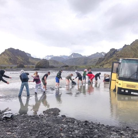 Hjálpast að við að afferma fasta rútu