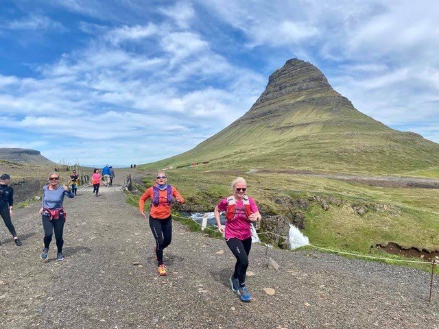 Eitt af frægari og fegurstu fjöllum landsins og ferðafélagsfólk á hlaupum í kring.